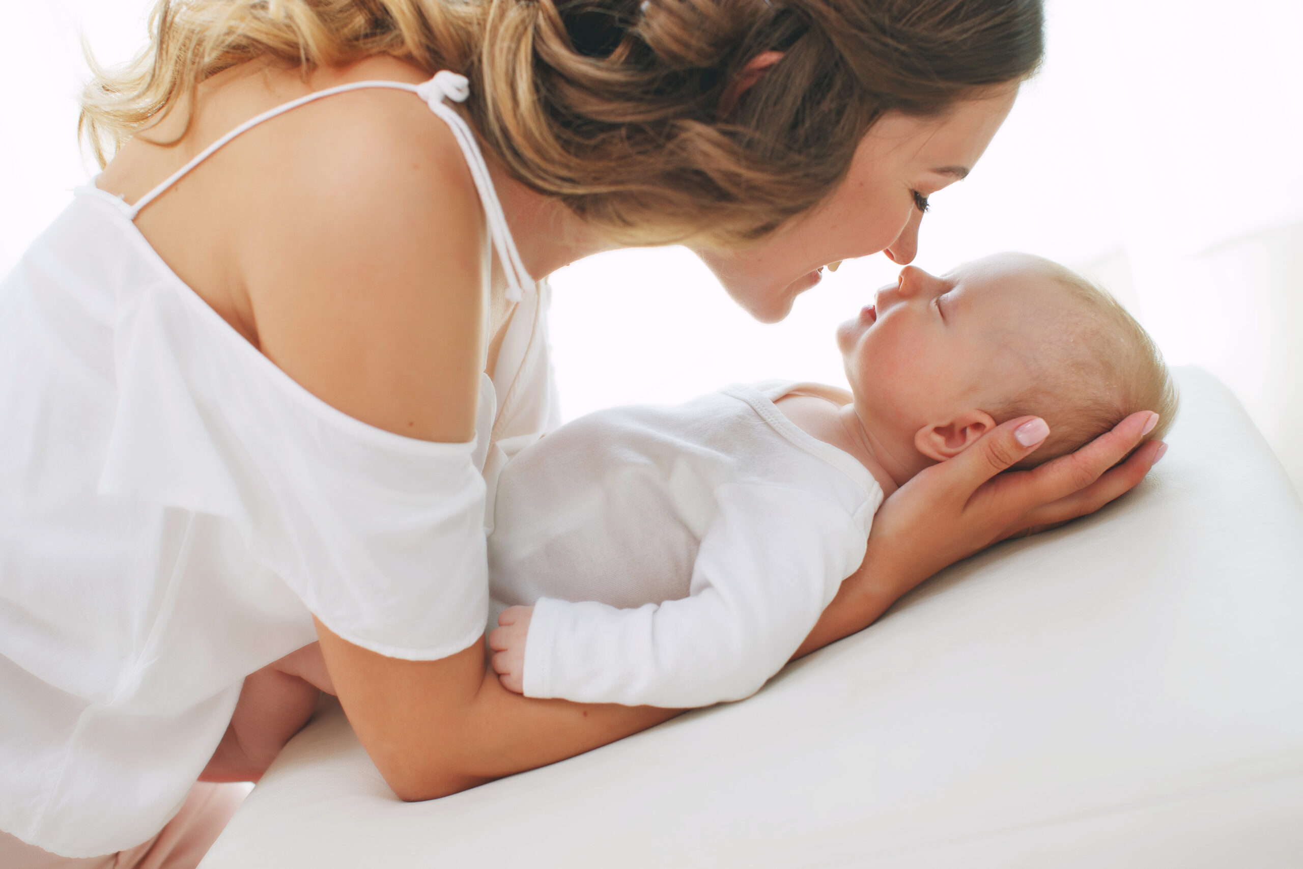 Young mother holding her newborn child. Mom nursing baby. Woman