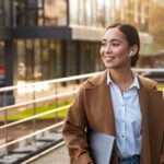 Young woman holding laptop in plaza