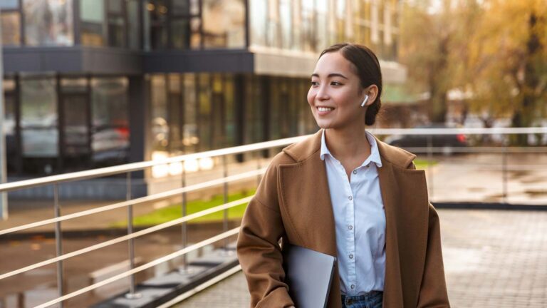 Young woman holding laptop in plaza