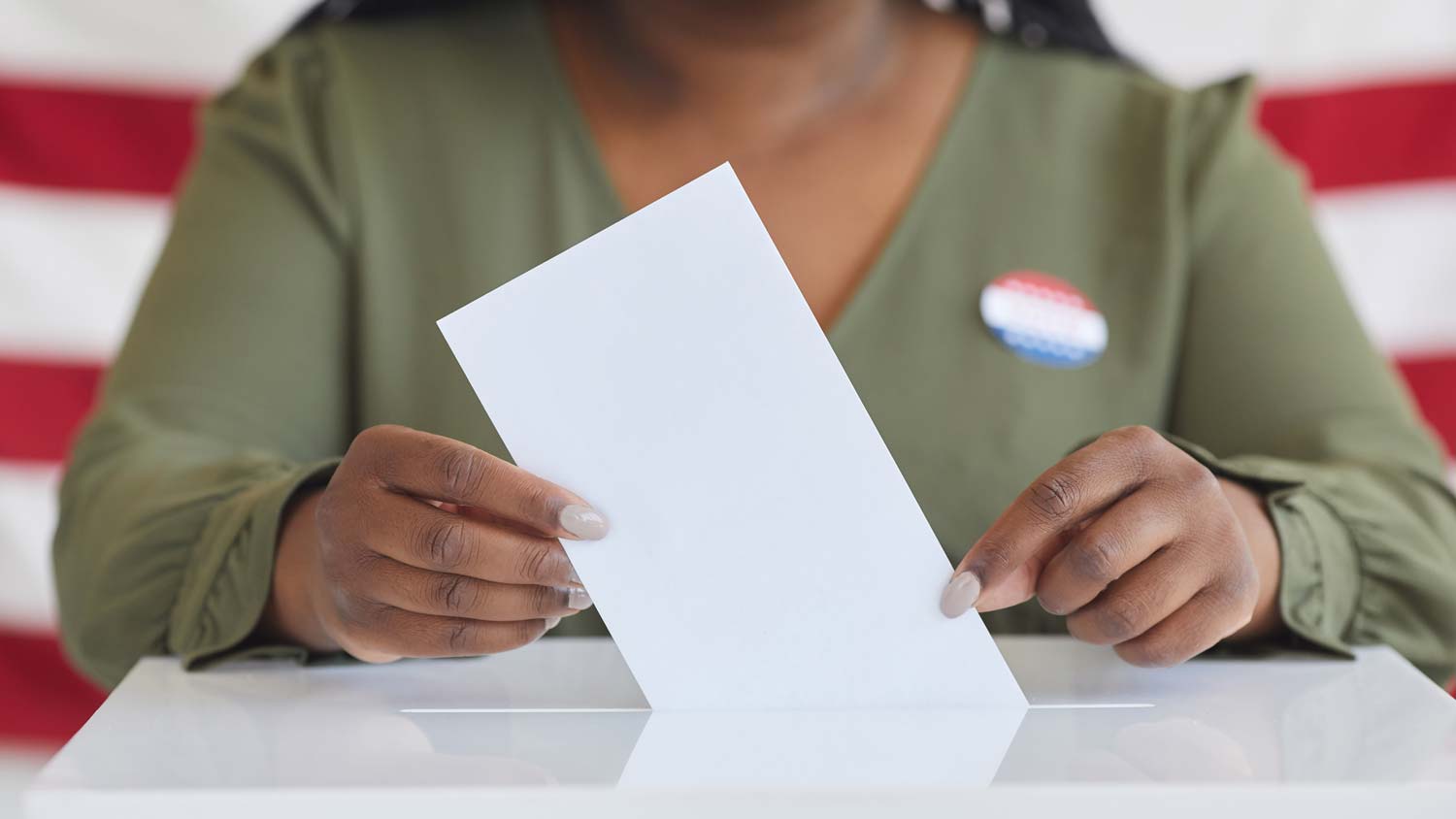 woman inserting card into ballot