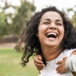 woman laughing with child on back
