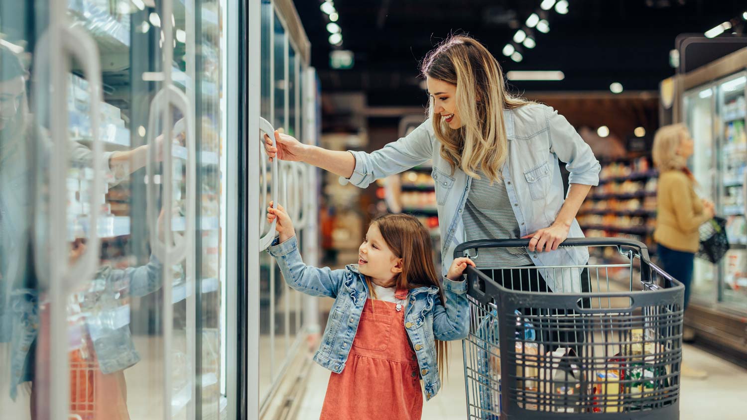 mother and daughter in freezer aisle