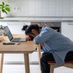 Exhausted freelancer resting head on table
