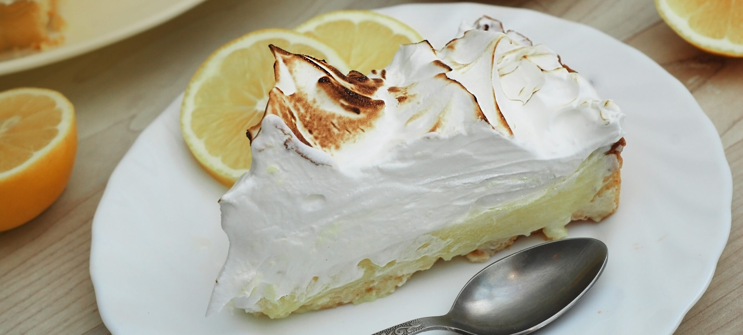 Lemon meringue pie on plate with spoon