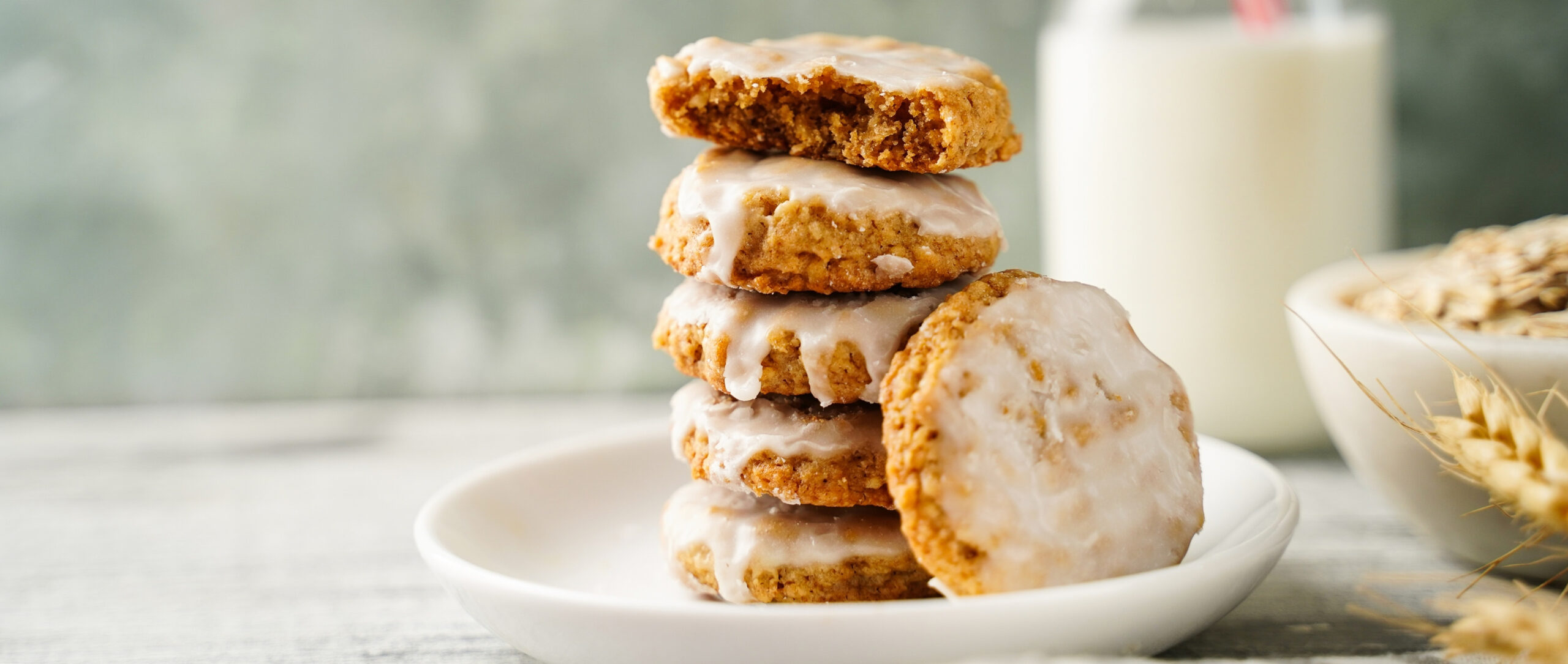 Homemade iced oatmeal cookies served with milk, selective focus